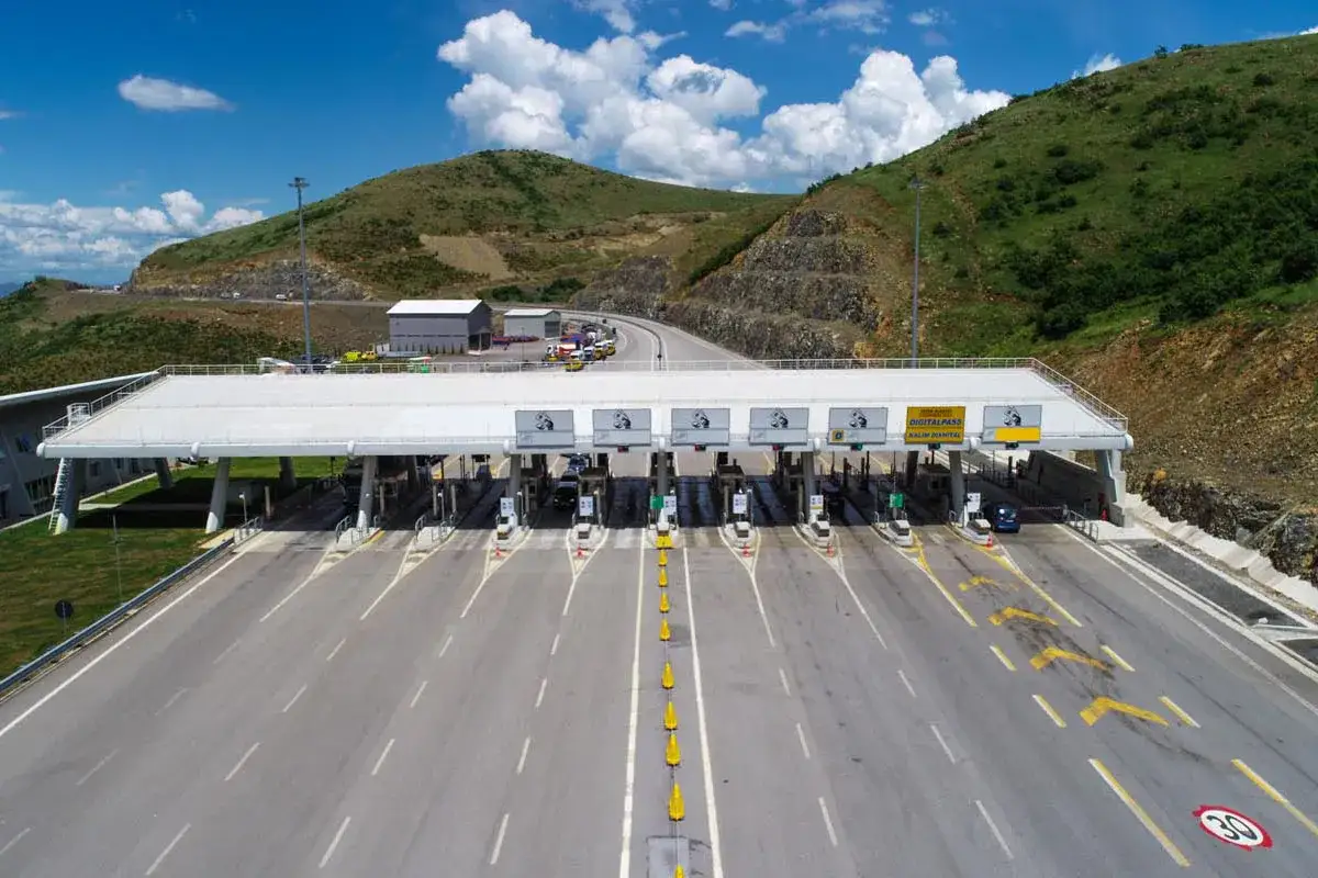Moderne Mautstation in Albanien mit mehreren Fahrspuren und Schildern für digitale Pässe.
