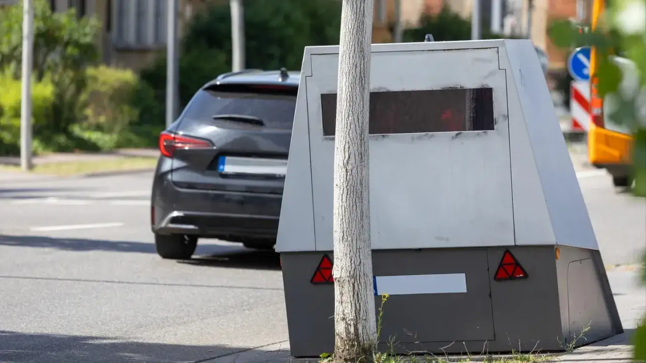 Ein Blitzer steht am Stra&szlig;enrand, bereit f&uuml;r den blitzermarathon rlp. Ein Auto f&auml;hrt vorbei.