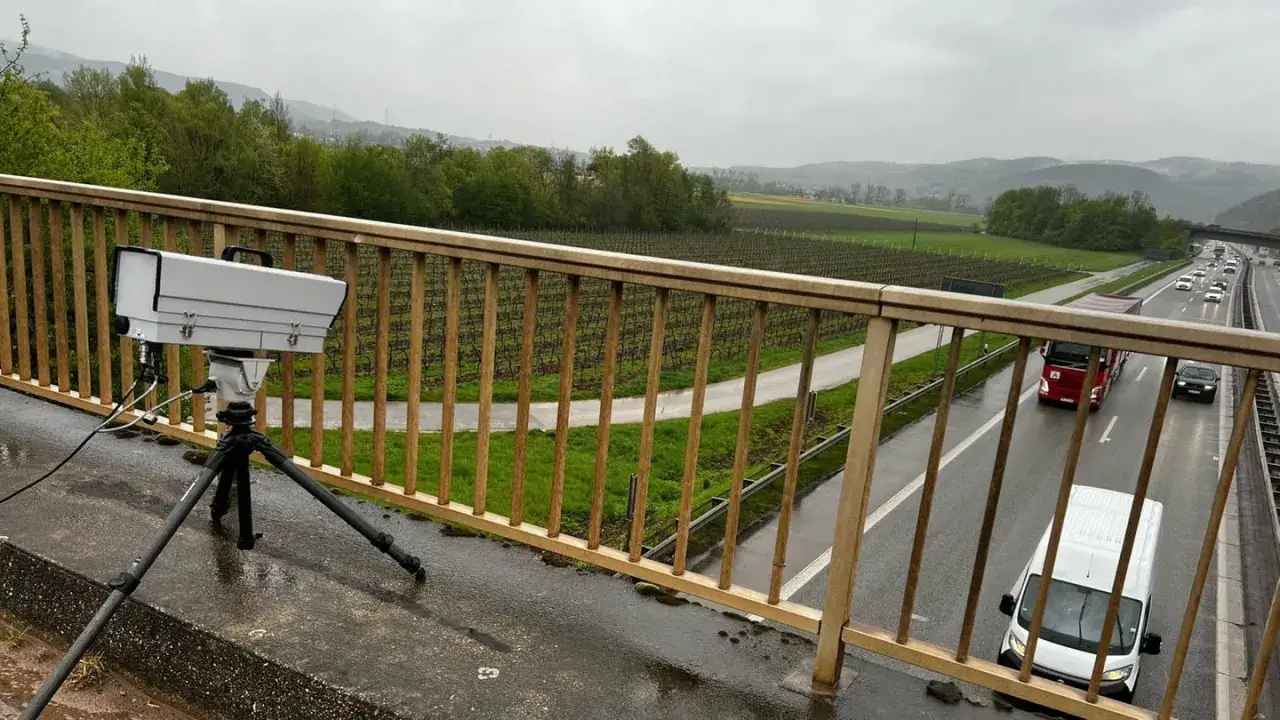 Ein handy blitzer steht auf einem Stativ, bereit, die vorbeifahrenden Autos auf der Autobahn zu überwachen.