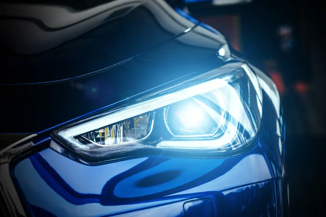 Blauer Scheinwerfer eines Autos leuchtet hell. Die