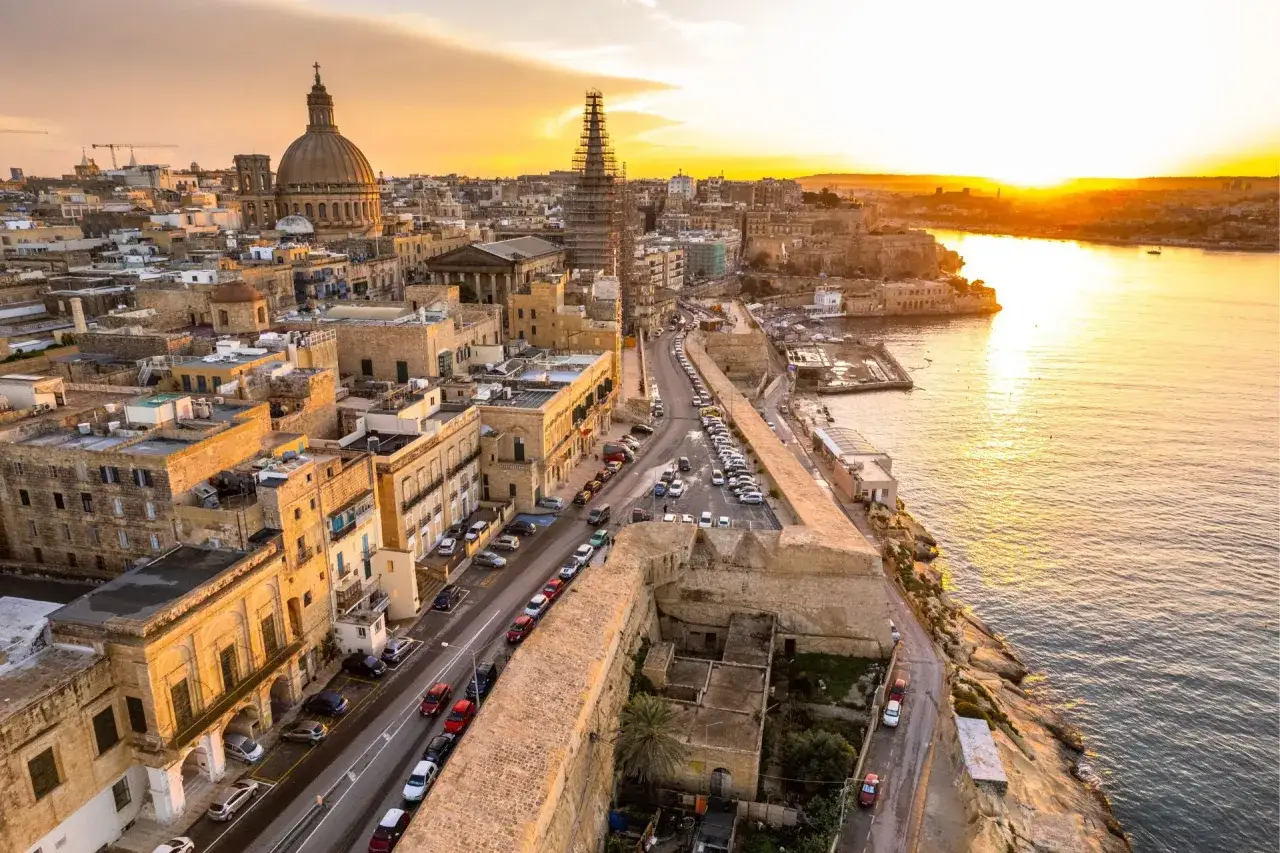 Sonnenuntergang über Valletta, Malta. Autos fahren auf der linken Seite der Straße, ein typisches Bild für Malta Linksverkehr.